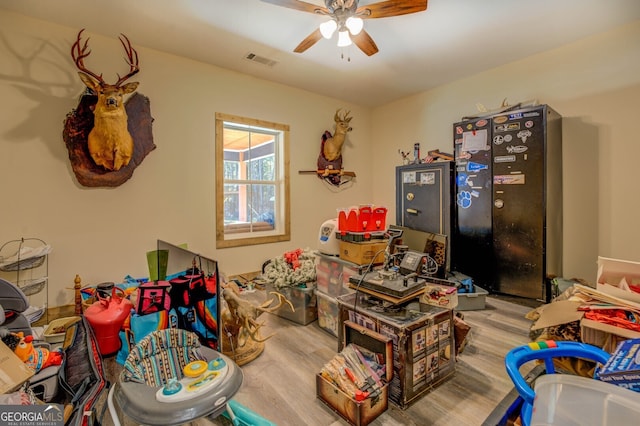 playroom with ceiling fan and light hardwood / wood-style flooring