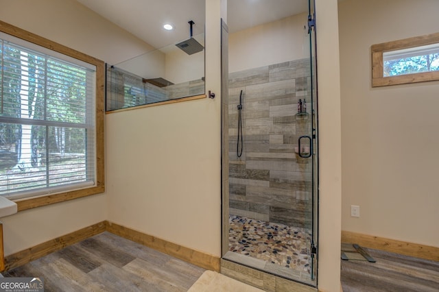 bathroom featuring wood-type flooring, plenty of natural light, and an enclosed shower