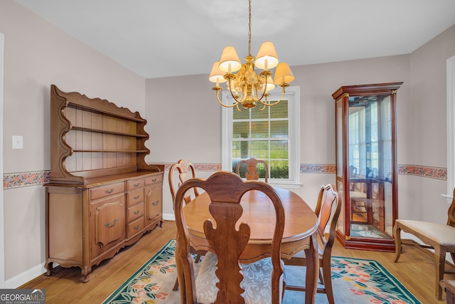 dining space with a chandelier and light hardwood / wood-style floors