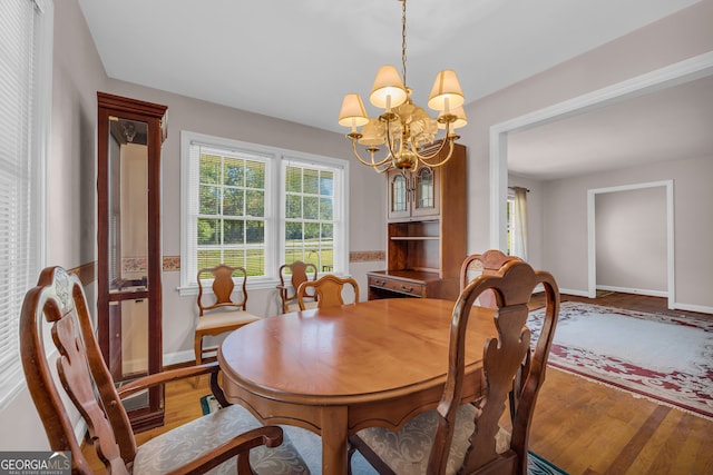 dining area featuring hardwood / wood-style floors and a chandelier