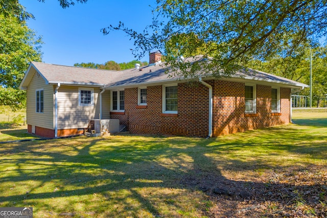 rear view of property with a lawn