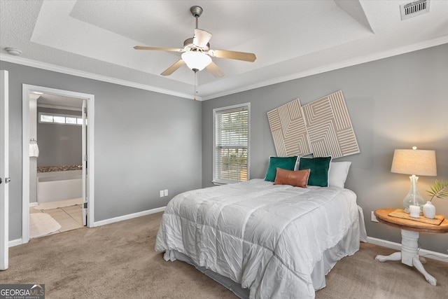 bedroom with ornamental molding, light carpet, and a tray ceiling