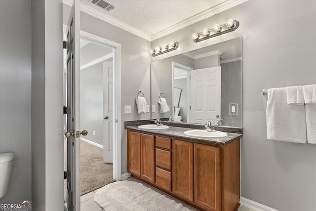 bathroom with vanity, ornamental molding, a textured ceiling, and toilet