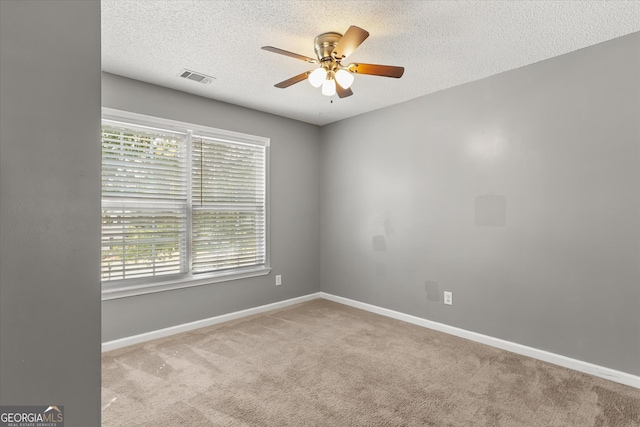 unfurnished room featuring light carpet, a textured ceiling, and ceiling fan