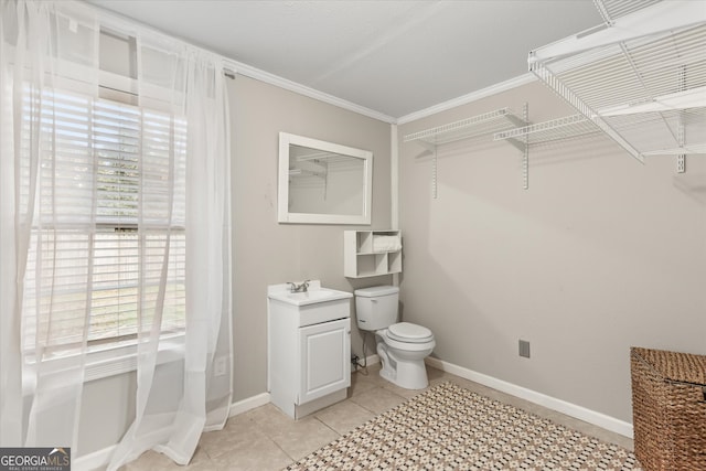 bathroom with toilet, crown molding, sink, and tile patterned floors