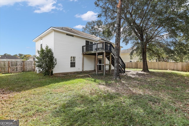 rear view of house featuring a yard and a wooden deck