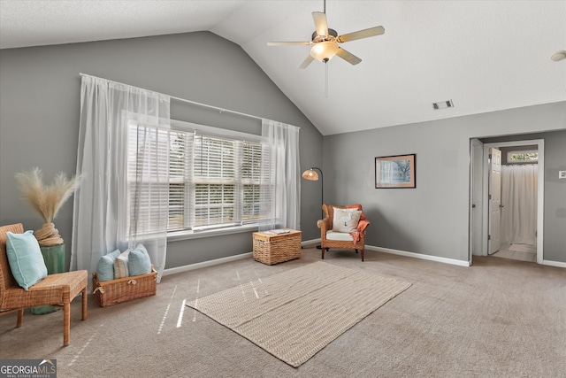 living area featuring vaulted ceiling, light colored carpet, and ceiling fan