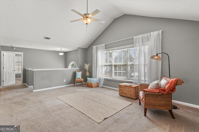 living area featuring carpet, vaulted ceiling, and ceiling fan