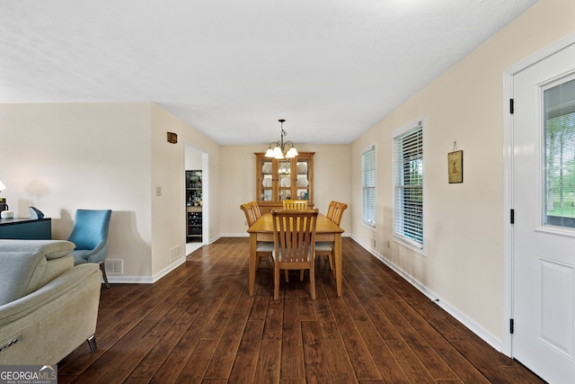 dining room with a notable chandelier and dark hardwood / wood-style flooring