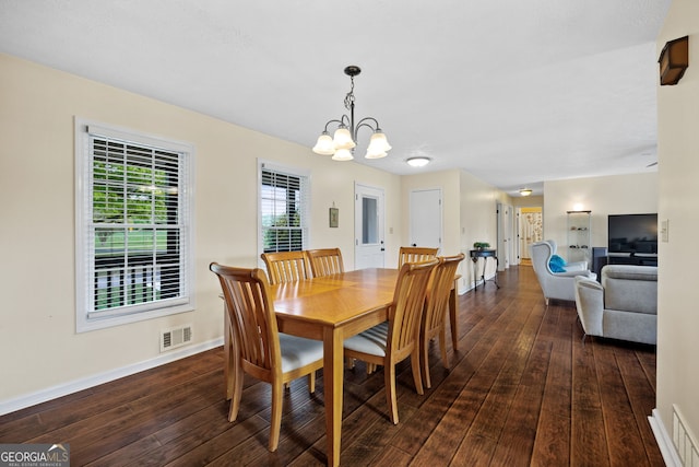 dining area featuring a notable chandelier and dark hardwood / wood-style flooring