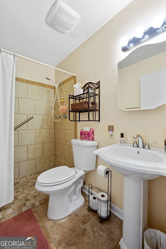 bathroom featuring sink, curtained shower, and toilet