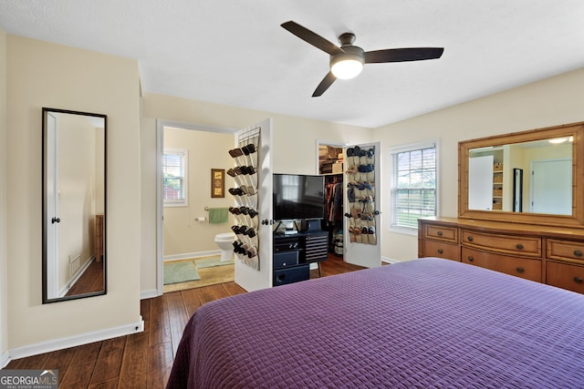 bedroom with a walk in closet, ensuite bath, dark hardwood / wood-style floors, a closet, and ceiling fan