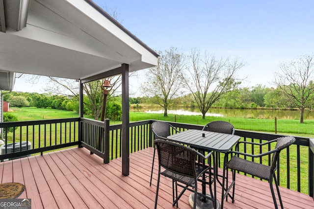 deck with a water view and a yard