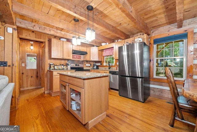 kitchen with hanging light fixtures, a kitchen island, light wood-type flooring, wooden walls, and stainless steel appliances