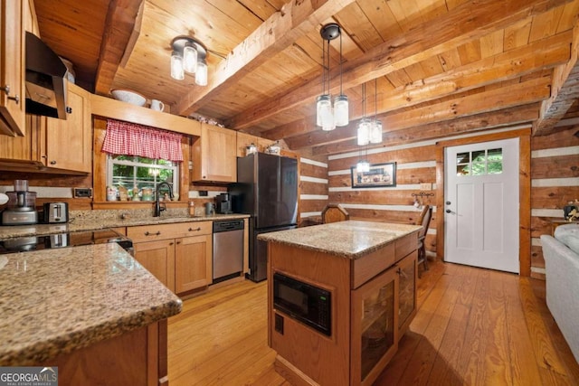 kitchen featuring beamed ceiling, a center island, light wood-type flooring, appliances with stainless steel finishes, and wood walls