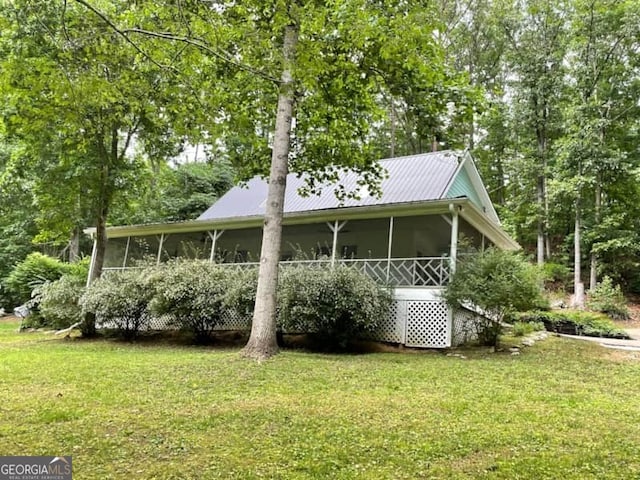 exterior space featuring a lawn and a sunroom