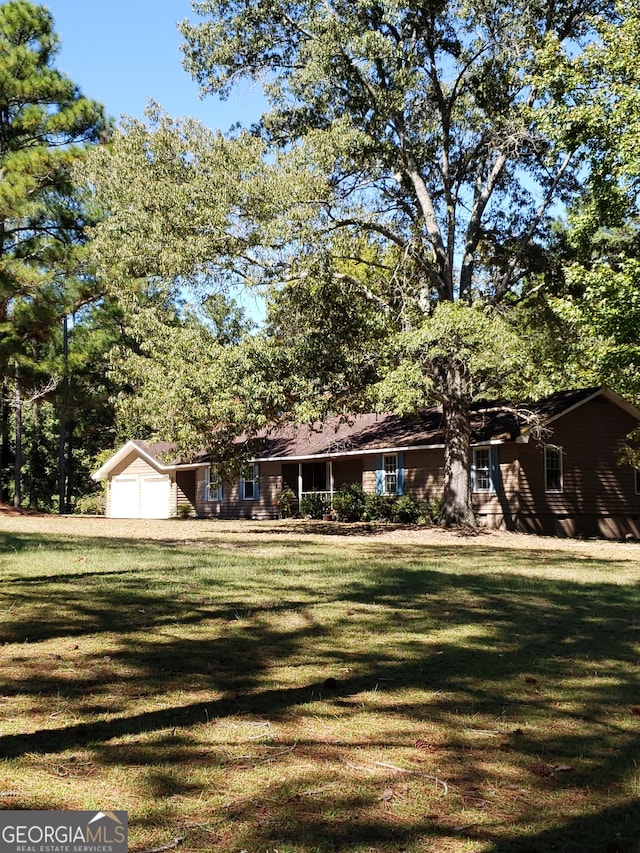 ranch-style home with a garage and a front lawn