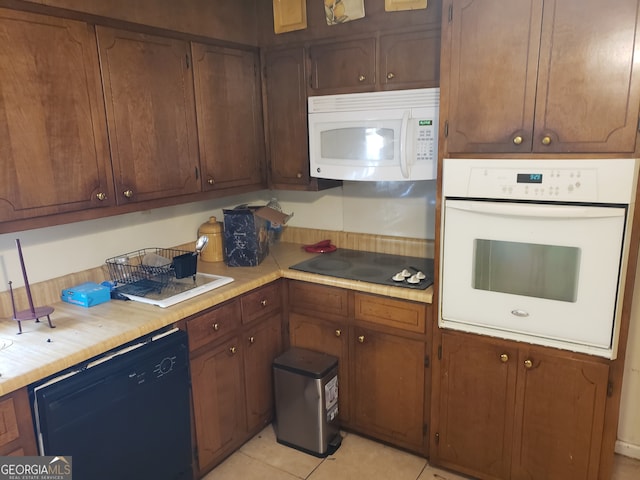 kitchen featuring black appliances and light tile patterned flooring