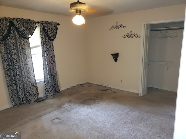 unfurnished bedroom featuring light carpet, a closet, and ceiling fan