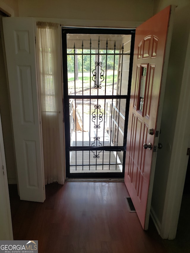 doorway with dark hardwood / wood-style floors