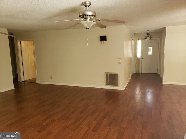 interior space with dark wood-type flooring, a textured ceiling, and ceiling fan