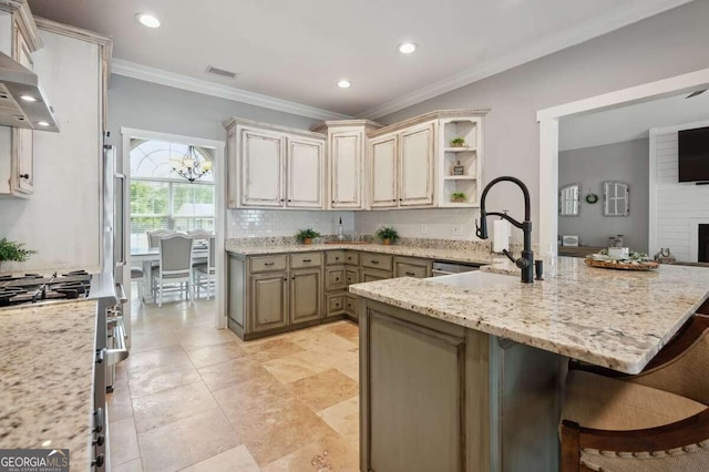 kitchen with cream cabinets, a chandelier, a kitchen bar, crown molding, and light stone counters