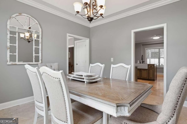 dining space with crown molding, a chandelier, and sink