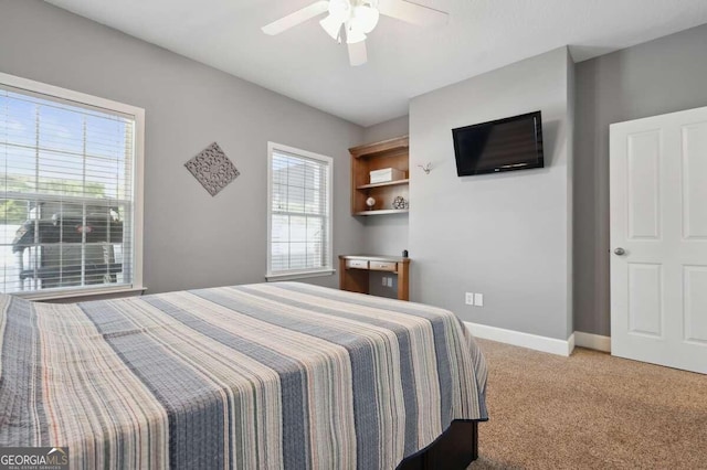 bedroom featuring ceiling fan, light carpet, and multiple windows