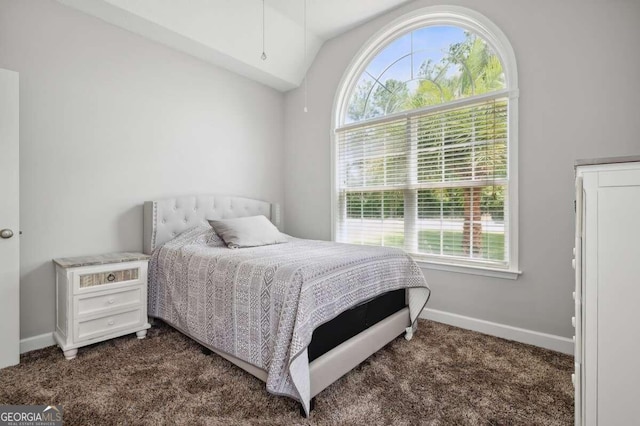 carpeted bedroom featuring vaulted ceiling and multiple windows