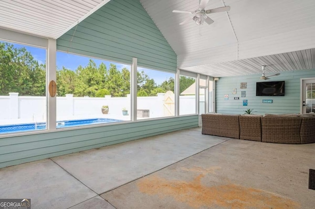 unfurnished sunroom with ceiling fan and vaulted ceiling