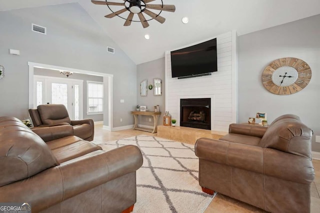 tiled living room with a large fireplace, high vaulted ceiling, and ceiling fan