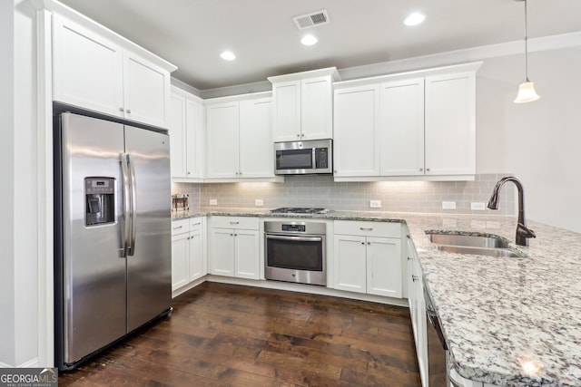 kitchen featuring appliances with stainless steel finishes, white cabinetry, dark hardwood / wood-style floors, pendant lighting, and sink