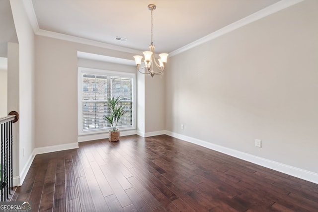 spare room featuring dark wood-type flooring, ornamental molding, and an inviting chandelier