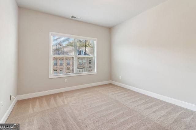 spare room featuring light carpet