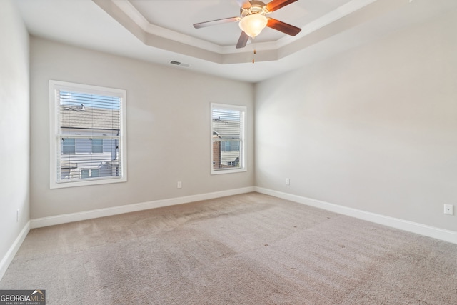 unfurnished room featuring carpet floors, a tray ceiling, and ceiling fan