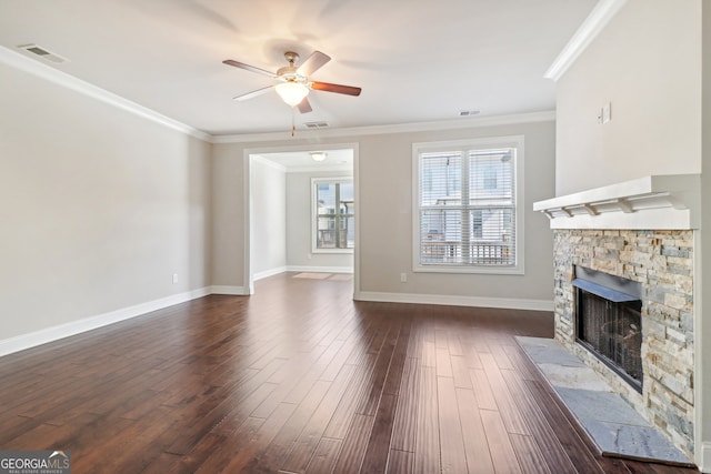 unfurnished living room featuring a stone fireplace, dark hardwood / wood-style floors, ceiling fan, and ornamental molding