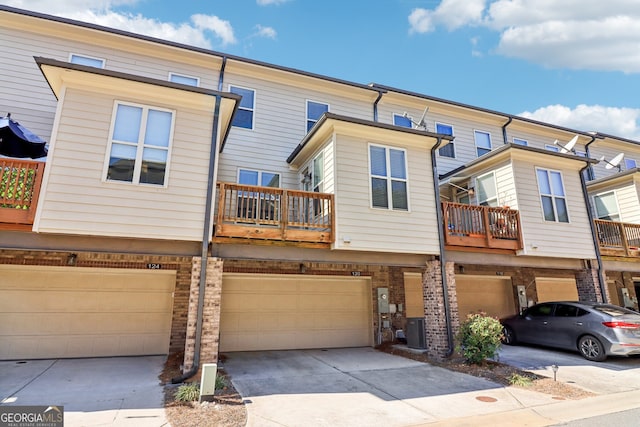 view of front of home featuring central air condition unit, a balcony, and a garage