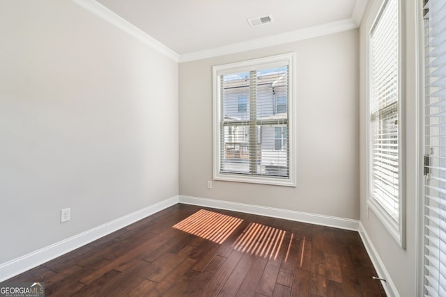 empty room with ornamental molding and dark hardwood / wood-style floors