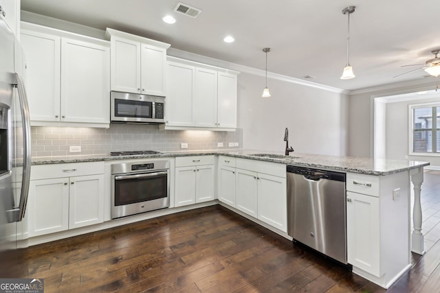 kitchen featuring dark hardwood / wood-style floors, stainless steel appliances, sink, decorative light fixtures, and white cabinets