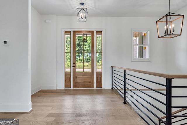 foyer entrance with a notable chandelier and light wood-type flooring