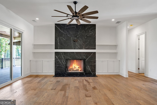 unfurnished living room with light hardwood / wood-style flooring, a fireplace, and ceiling fan