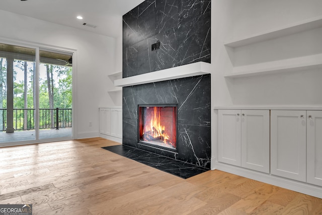 room details with a premium fireplace and hardwood / wood-style flooring