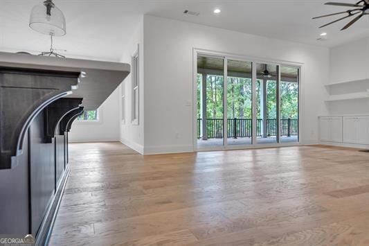 unfurnished living room featuring light hardwood / wood-style flooring and ceiling fan