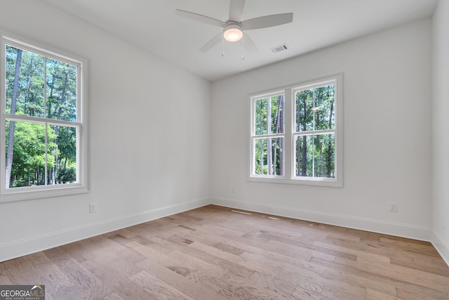 spare room featuring light hardwood / wood-style floors, a wealth of natural light, and ceiling fan