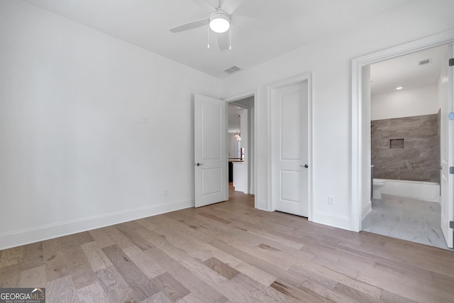 unfurnished bedroom featuring ceiling fan, light wood-type flooring, and ensuite bath