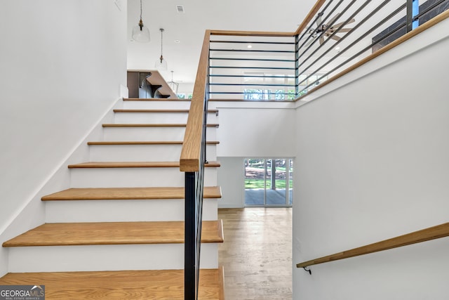 staircase featuring hardwood / wood-style floors and a high ceiling