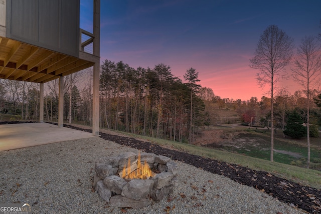 yard at dusk featuring a patio area and an outdoor fire pit