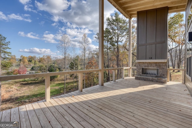 deck with an outdoor stone fireplace