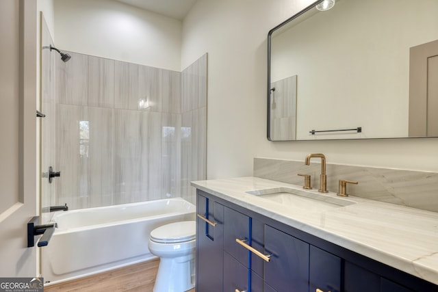 full bathroom featuring vanity, toilet, tiled shower / bath combo, and hardwood / wood-style floors