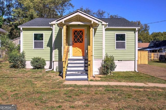 bungalow-style house with a front yard and a garage